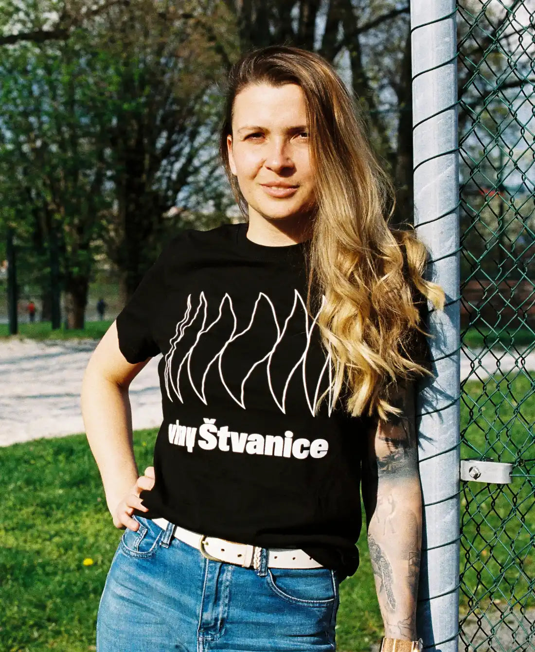 Dívka černé triko stojí na sluníčku, blondýna, fotbalová brána