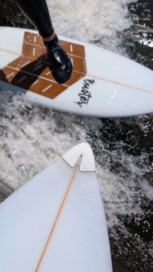 Nose Guard Buster a Surfové prkno, na kterém je vidět korkový front pad RSPro