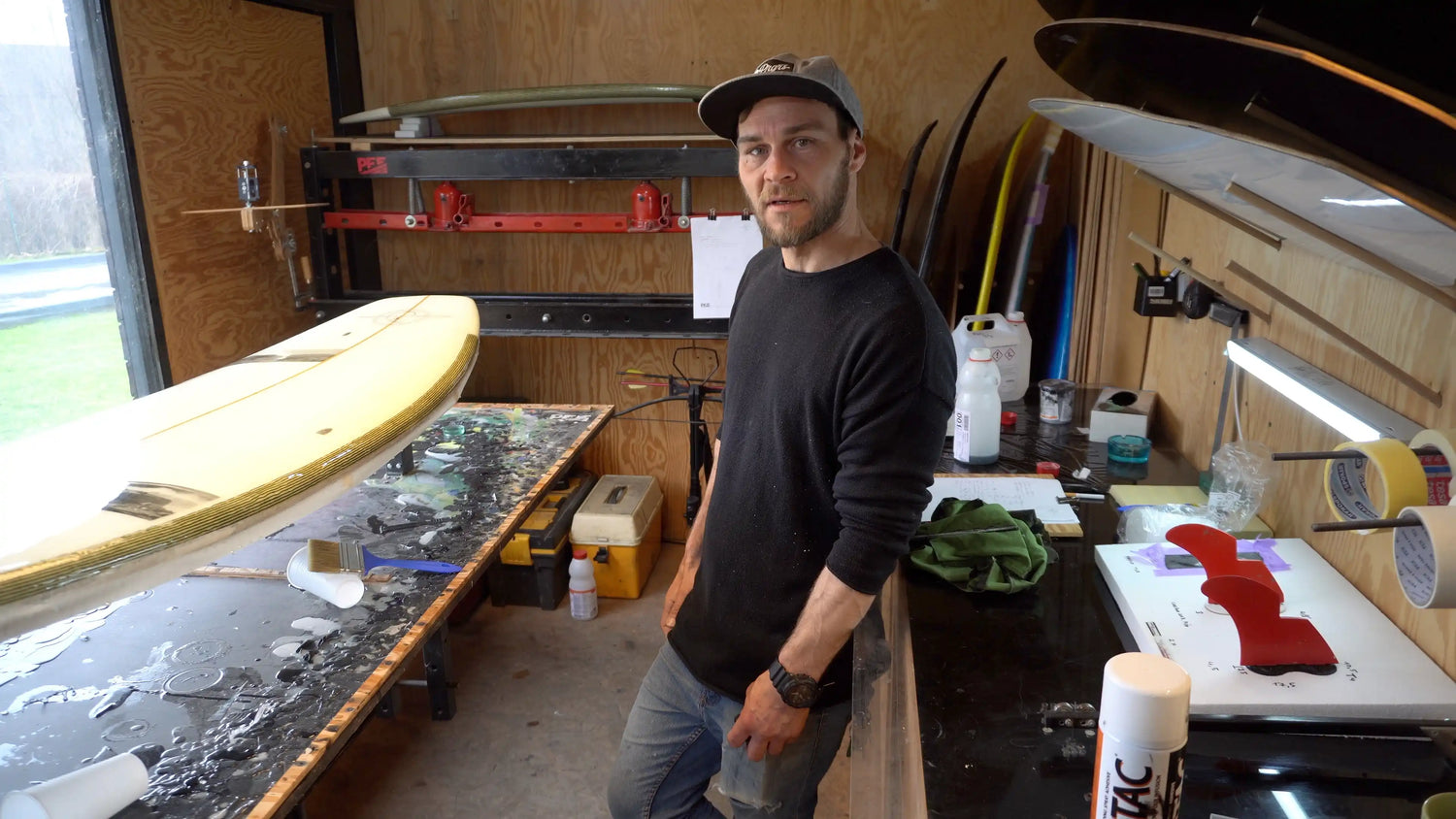 Shaper Martin Brandýs stojí ve své dílně, P.E.F. surfboards, river surfboard shaper, ovce v pozadí