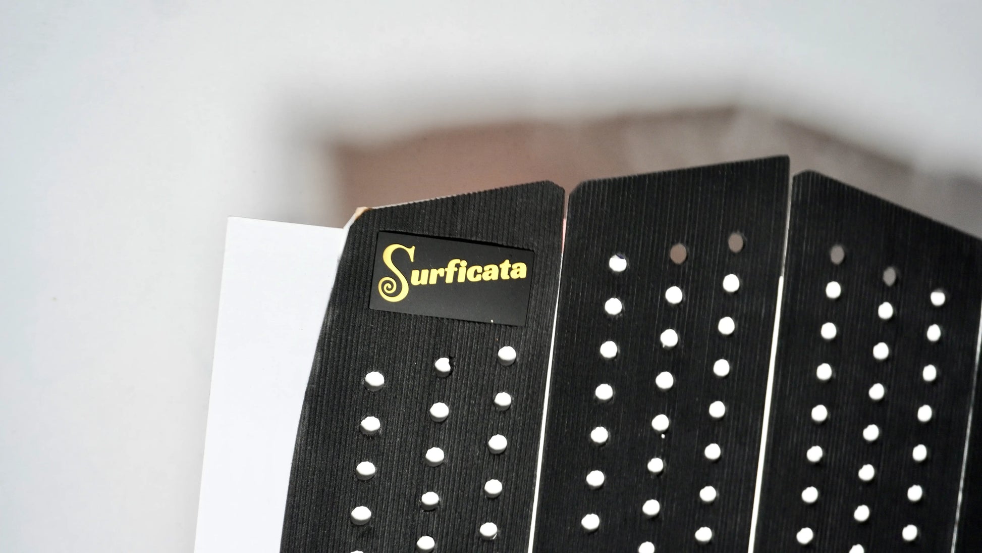 detail gripu s logem Surficata Black Edition – přední část surfového padu