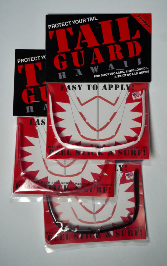 Balení SurfCo Hawaii Tail Guard Kit – různé barevné varianty (černá, průhledná, bílá) v originálním obalu, peel-stick instalace.