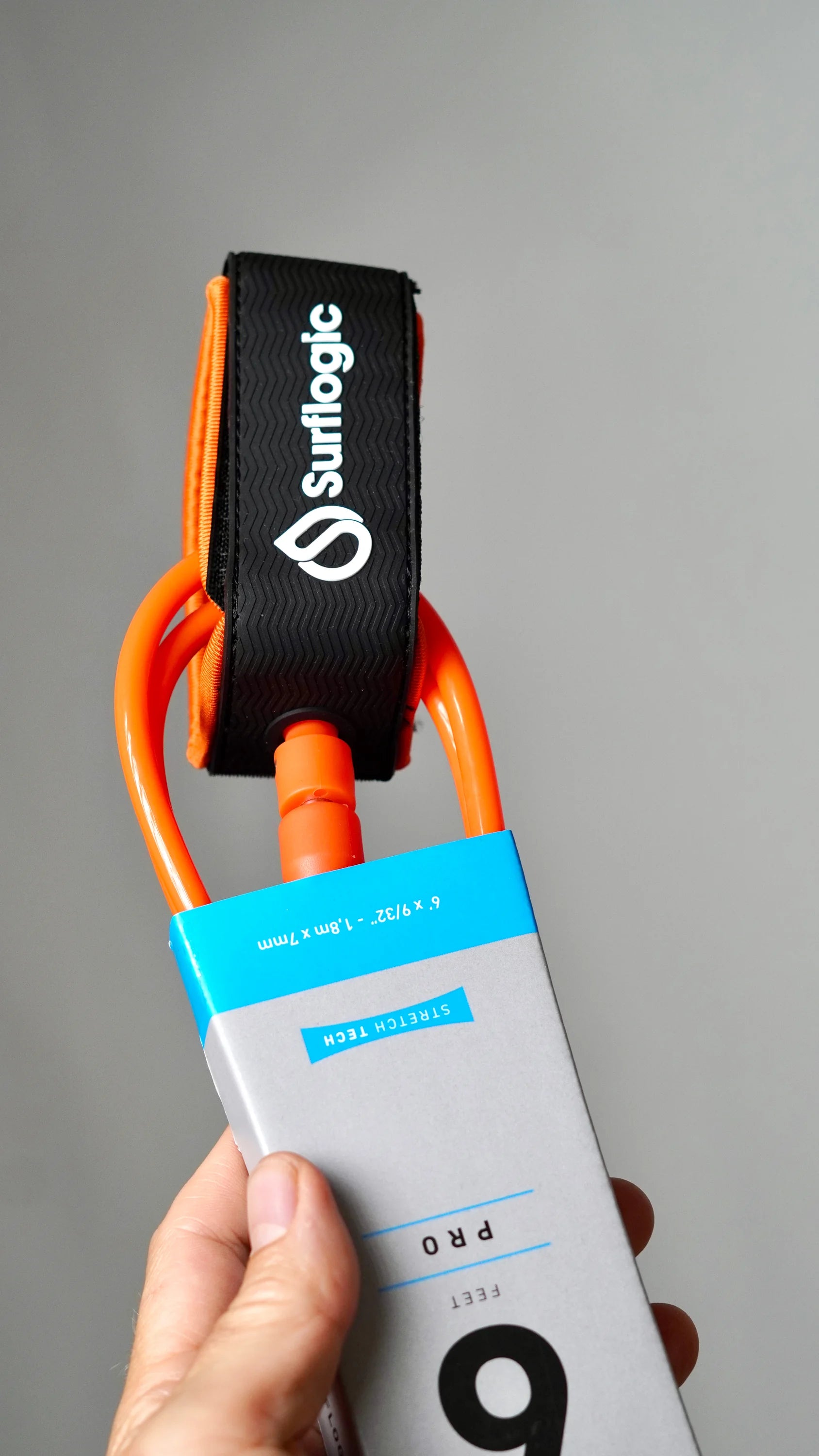 Close-up of the orange Surflogic leash with ankle cuff and cord connector