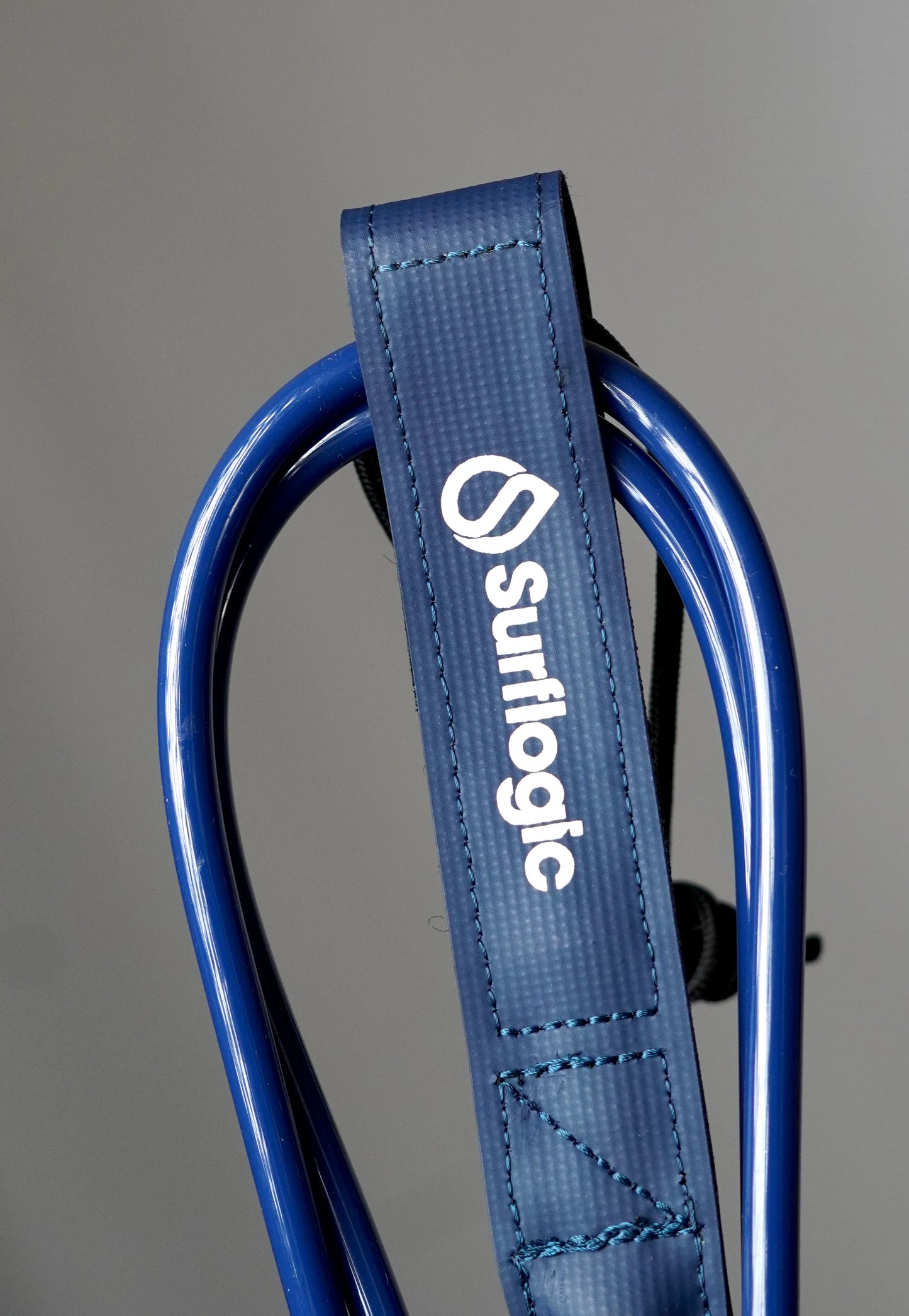 Close-up of the navy Surflogic leash with coiled blue cord