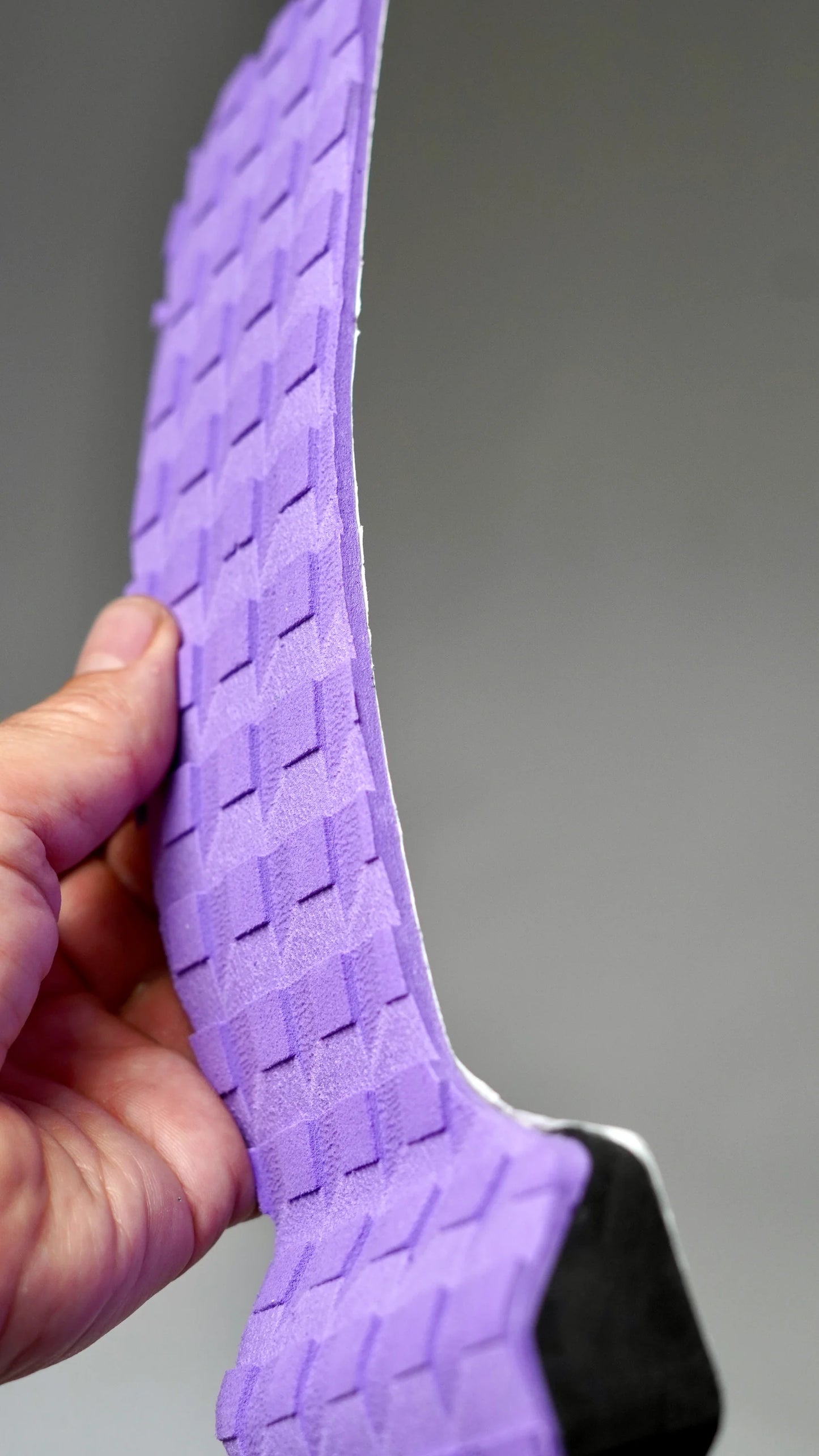 Boční pohled na fialový tail pad Surficata Purple Haze s tenkým EVA profilem a černou spodní vrstvou.