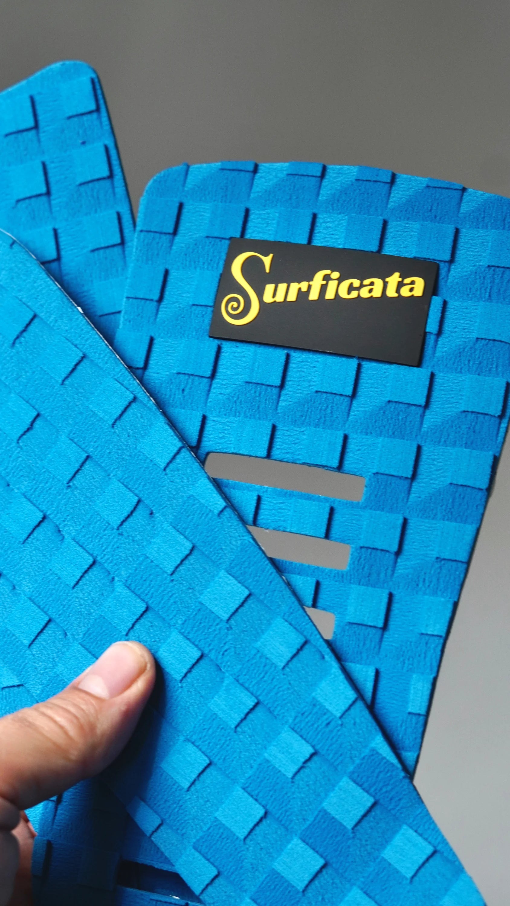Detail modrého tail padu Surficata Electric Blue s logem, podélnými výřezy a EVA strukturou.