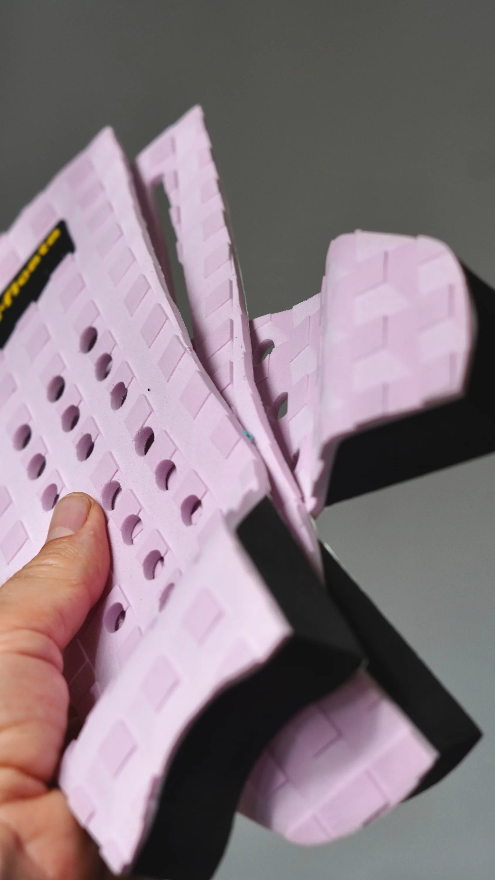 Ohebný růžový tail pad Surficata Pink Flamingo s viditelnou černou spodní vrstvou.