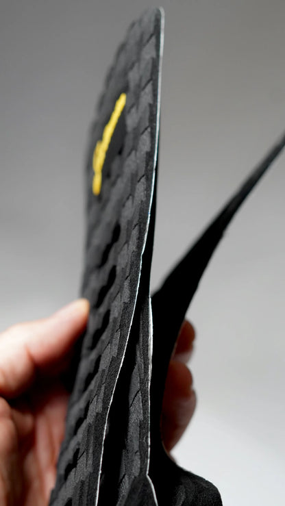 Boční pohled na černý tail pad Surficata Blackout s tenkým EVA profilem.